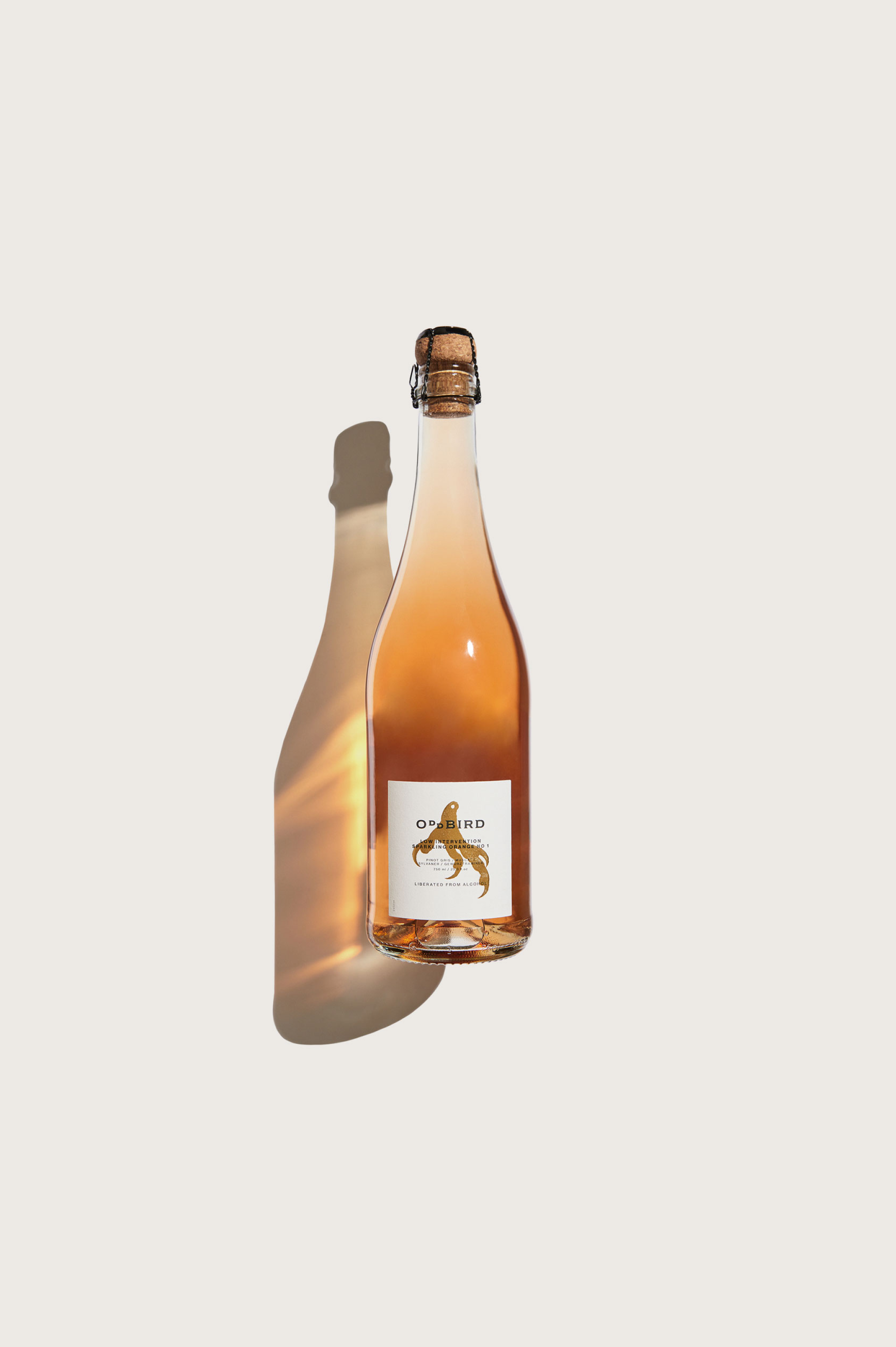 Bottle of orange wine with a label on a light beige background